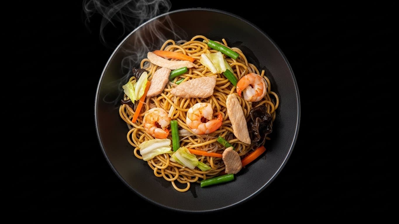 Steaming pancit noodles with shrimp, chicken, and fresh vegetables